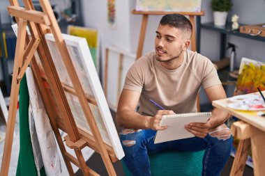 Genç İspanyol ressam resim stüdyosunda kendine güvenen çizimler yapıyor.