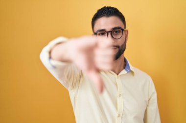 İş kıyafetleri ve gözlük takan İspanyol genç adam mutsuz ve kızgın görünüyor. Reddedilmiş ve olumsuz jest yapıyor. kötü ifade. 