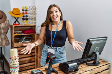 Genç esmer kadın perakende dükkanında açık mesajla pankart tutuyor. Neşeli gülümsüyor, kollarını açıyor. Dostça karşılama, olumlu ve kendinden emin selamlar. 