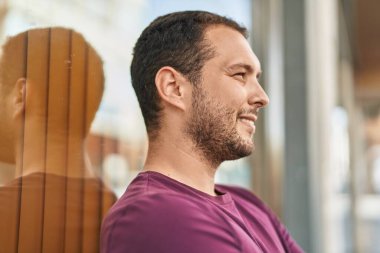 Young man smiling confident looking to the side at street