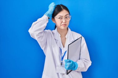 Bilim adamlarının laboratuvarında çalışan Çinli genç bir kadın soru sorup kafasını karıştırıyor. Şüpheyle kararsız, kafa kafaya düşünerek. Düşünceli kavram. 