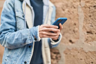 Sokakta akıllı telefon kullanan genç bir İspanyol.