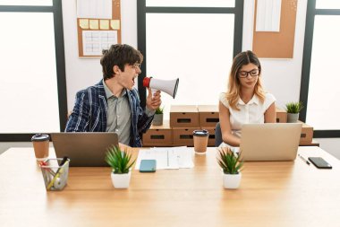 İş adamı ofiste megafonla ortağına bağırıyor..