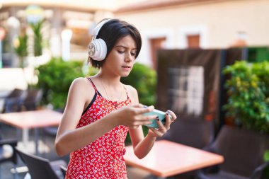 Sokakta konsantre ifadesiyle video oyunu oynayan sevimli İspanyol kız.