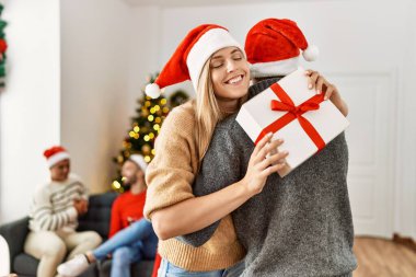 Bir grup genç insan noel toplantısındalar. Bir çift hediye alıp evde kucaklaşıyorlar..