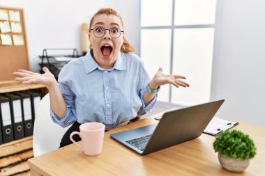 Ofiste çalışan genç, kızıl saçlı bir kadın çılgınca kutlama yapan bir bilgisayar kullanıyor ve kolları açık, gözleri açık heyecanla haykırarak başarıya hayret ediyor. Kazanan konsept 