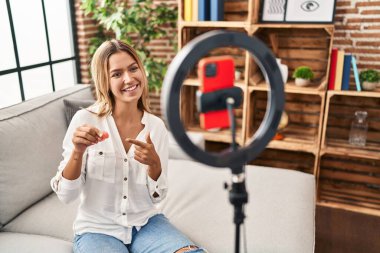 Genç İspanyol kadın regl fincanı videosu kaydediyor.