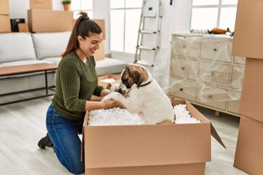 Evde köpekle oynarken kendine güvenen genç bir kadın.