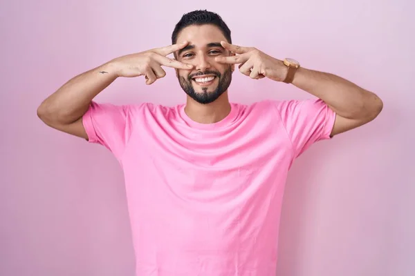 Hispanic Ung Man Står Över Rosa Bakgrund Gör Fred Symbol — Stockfoto