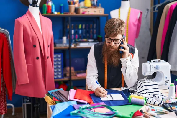 Giovane Redhead Uomo Sarto Parlando Smartphone Scrittura Notebook Fabbrica Abbigliamento — Foto Stock