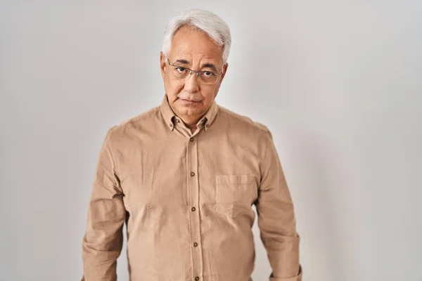 Hispanic senior man wearing glasses depressed and worry for distress, crying angry and afraid. sad expression.