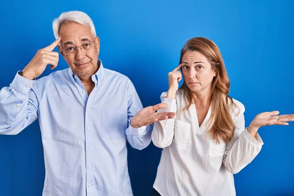 Middle Age Hispanic Couple Standing Blue Background Confused Annoyed Open — kuvapankkivalokuva