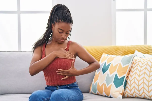 Afroamerikanerin Untersucht Brust Mit Hand Auf Sofa Hause — Stockfoto