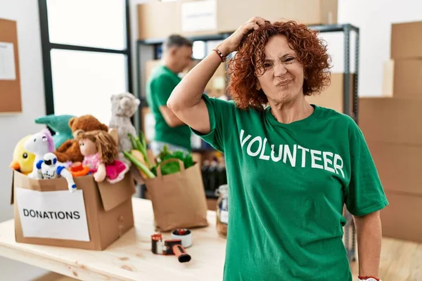 Bağışlarda Gönüllü Tişört Giyen Orta Yaşlı Bir Kadın Soru Işaretleri — Stok fotoğraf