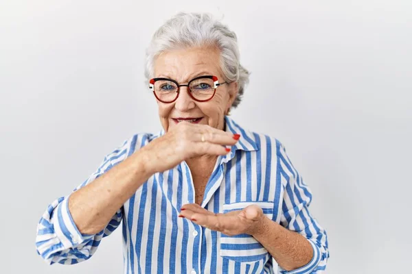 Starsza Kobieta Siwymi Włosami Stojąca Nad Białym Tłem Gestykulująca Dłońmi — Zdjęcie stockowe