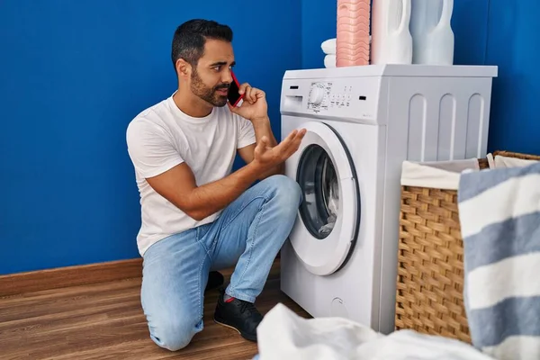 Joven Hombre Hispano Hablando Teléfono Inteligente Lavandería —  Fotos de Stock