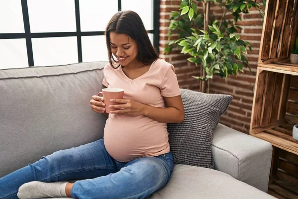 Young Latin Woman Pregnant Drinking Coffee Sitting Sofa Home — Stockfoto