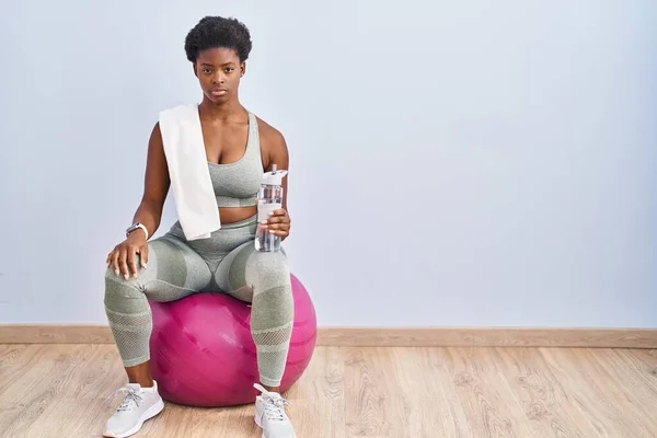 Afroamerikansk Kvinna Sportkläder Sitter Pilatesboll Avslappnad Med Allvarliga Ansiktsuttryck Enkel — Stockfoto