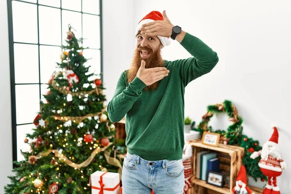 Redhead Man Long Beard Wearing Christmas Hat Christmas Tree Smiling — Zdjęcie stockowe