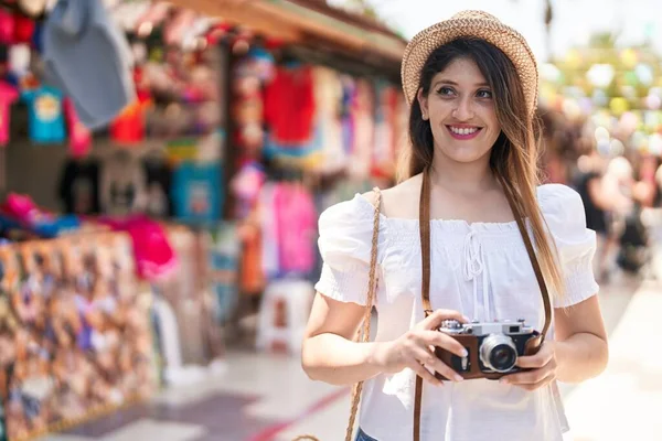 ストリートマーケットでカメラを使って自信を持って笑顔若いヒスパニック女性観光客 — ストック写真