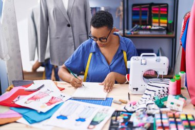 Terzide defter çizen Afrikalı Amerikalı kadın terzi.