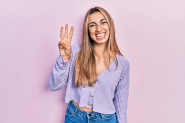 Gündelik tişört giyen güzel İspanyol kadın üç numarayı gösterip işaret ederken kendinden emin ve mutlu gülümsüyor.. 