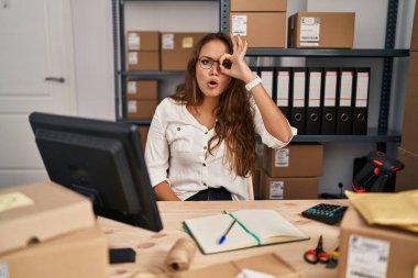 Küçük işletme şirketinde çalışan Latin kökenli genç bir kadın şaşırmış yüz ifadesiyle şaşırmış, parmaklarından bakan bir jest yapıyor. İnançsız ifade. 