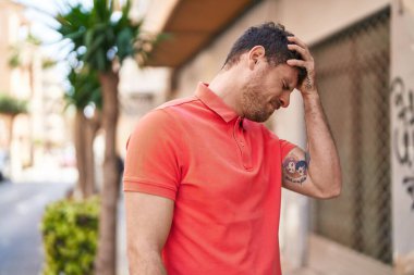 Genç İspanyol adam sokakta baş ağrısı çekiyor.