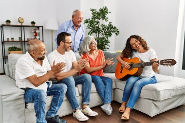 Bir grup orta yaşlı arkadaş evdeki kanepede oturup klasik gitar çalıyorlar..