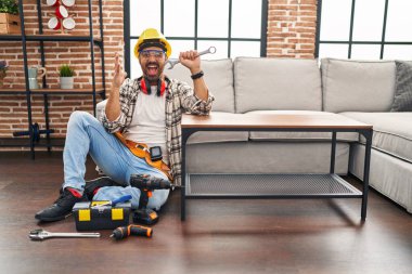 Sakallı genç İspanyol adam mutlu bir gülümsemeyle zaferi kutluyor ve ellerini kaldırarak zafer ifadesi takınıyor. 