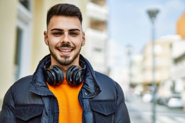 Yakışıklı, sakallı, neşeli ve kendine güvenen, kışlık palto giyen bir İspanyol.