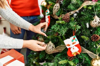 Mutlu gülümseyen genç çift evde Noel şapkası takıyor..