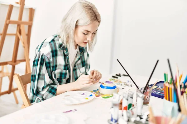 Young artist student girl relaxed painting pottery at art studio.