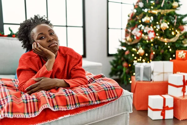 Młoda Afroamerykanka Leżąca Kanapie Obok Choinki Myśląc Wygląda Zmęczoną Znudzoną — Zdjęcie stockowe