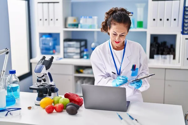 Laboratuvarda çalışan orta yaşlı İspanyol kadın.