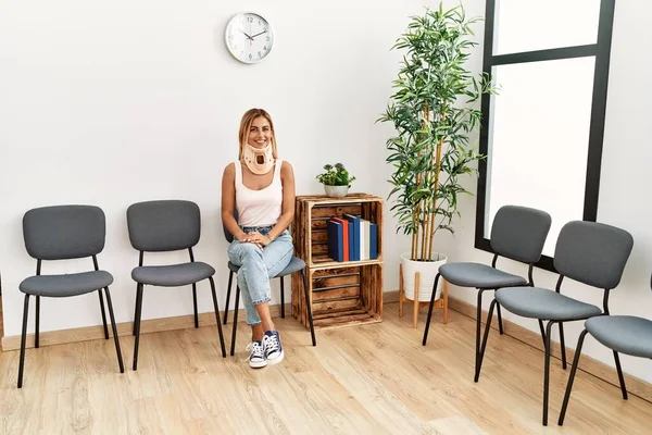 Kafkasyalı yaralı genç kız gülümsüyor. Yaka takıyor, doktor bekleme odasında oturuyor..