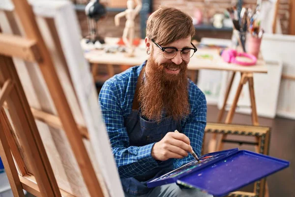 年轻红头发的艺术家在艺术工作室里自信地微笑着画画 — 图库照片