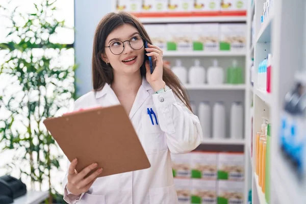 Jovem Farmacêutico Mulher Caucasiana Falando Documento Leitura Smartphones Farmácia — Fotografia de Stock