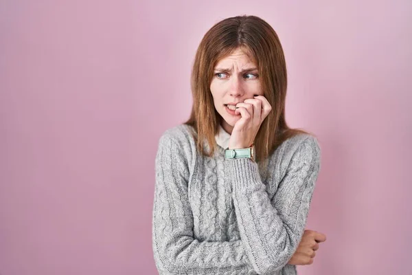 분홍색 아름다운 여인은 손으로 손톱을 물면서 긴장하고 긴장하고 있었다 — 스톡 사진