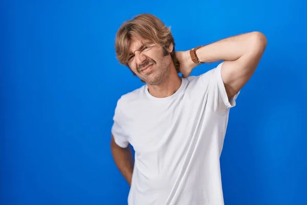 Middelbare Leeftijd Man Staande Blauwe Achtergrond Lijden Aan Nek Pijn — Stockfoto