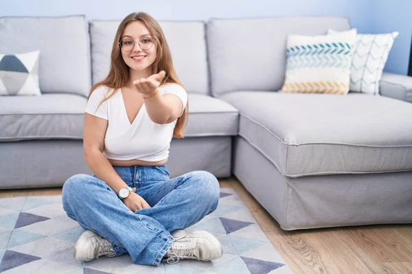 Mladá Běloška Sedí Podlaze Obývacím Pokoji Vesele Usmívá Nabízí Dlaň — Stock fotografie