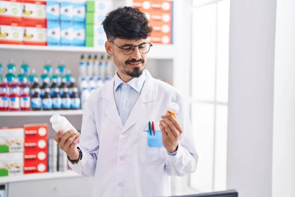 Young Hispanic Man Pharmacist Smiling Confident Holding Pills Bottles Pharmacy — Fotografia de Stock