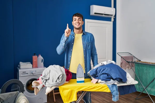 Joven Hombre Hispano Planchando Ropa Casa Sonriendo Con Una Idea — Foto de Stock