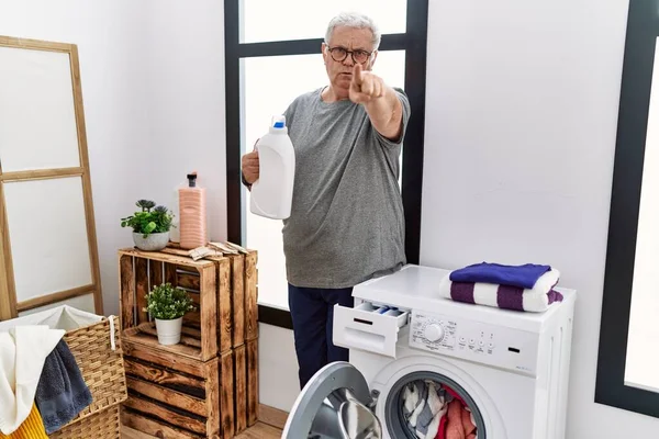 Hombre Caucásico Mayor Lavando Ropa Sosteniendo Botella Detergente Señalando Con — Foto de Stock