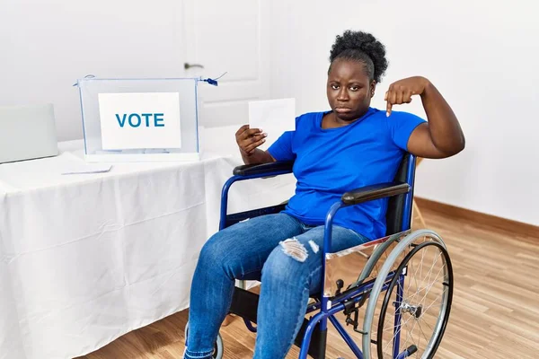 Młoda Afrykanka Siedząca Wózku Inwalidzkim Głosująca Umieszczając Urnie Wyborczej Wskazując — Zdjęcie stockowe