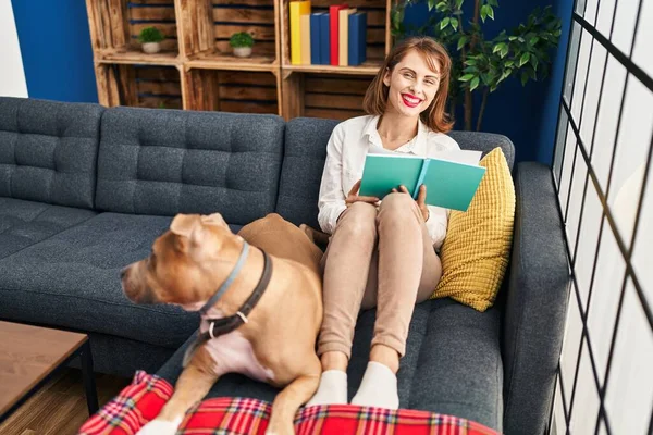 Junge Kaukasierin Liest Buch Und Sitzt Mit Hund Hause Auf — Stockfoto
