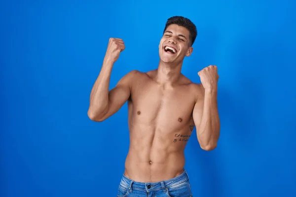 Joven Hombre Hispano Pie Sin Camisa Sobre Fondo Azul Celebrando —  Fotos de Stock