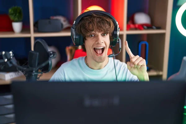 Jovem Hispânico Jogando Videogames Sorrindo Com Uma Ideia Pergunta Apontando — Fotografia de Stock