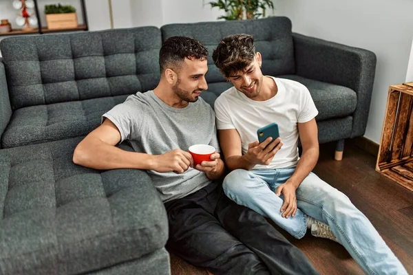 Dois Homens Hispânicos Casal Usando Smartphone Beber Café Casa — Fotografia de Stock