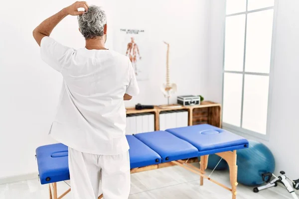 Middle Age Hispanic Therapist Man Working Pain Recovery Clinic Backwards — Stock Photo, Image